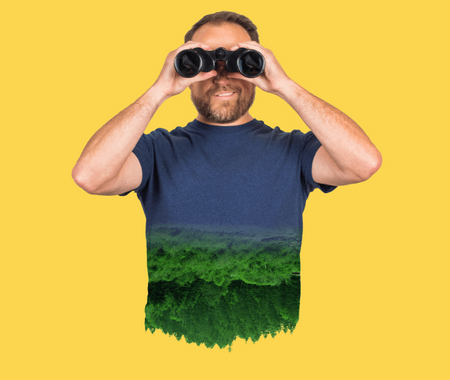 Image of a man holding binoculars to his eyes. He's wearing a shirt with trees printed on it and standing in front of a yellow background.